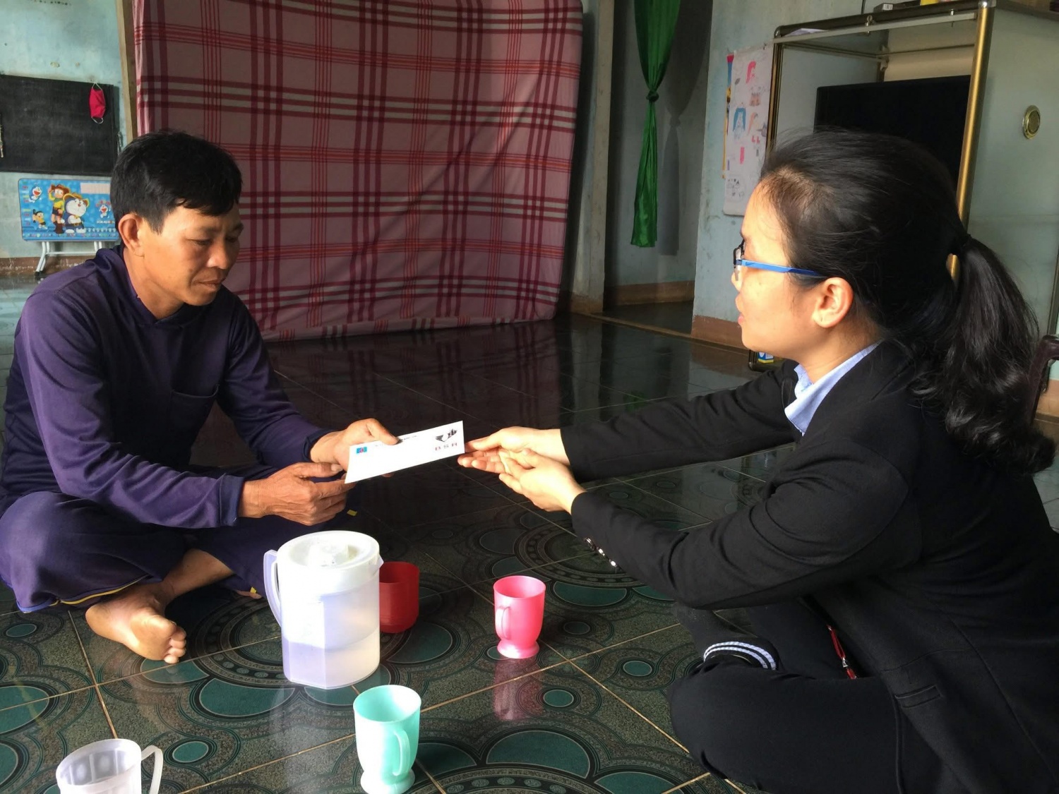 Chị Hiền Giang (bên phải) trao quà hỗ trợ cho gia đình có hoàn cảnh khó khăn ở huyện Bình Sơn, Quảng Ngãi