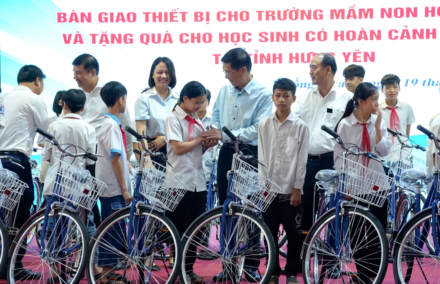 Đồng chí Trần Quang Dũng cùng các đại biểu trao tặng xe đạp cho các em học sinh có hoàn cảnh đặc biệt, đạt thành tích cao trong học tập tại xã Hồng Quang.