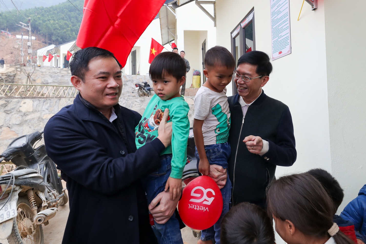 Chủ tịch HĐTV PETROVIETNAM Lê Ngọc Sơn và Phó Bí thư Thường trực Đảng ủy PETROVIETNAM Trần Quang Dũng cùng với trẻ em tại khu tái định cư thôn Kho Vàng.